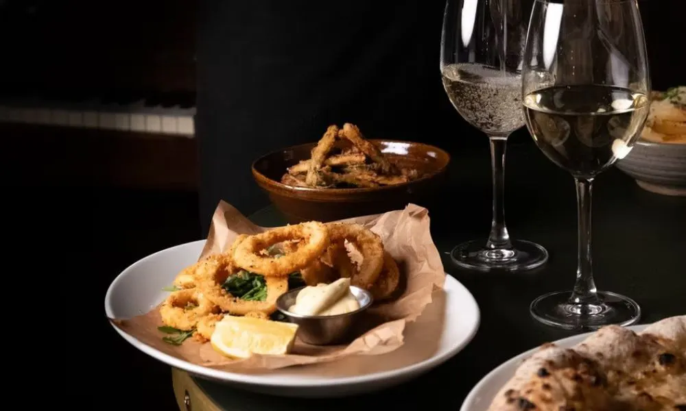 waiter pouring glass of wine and onion rings