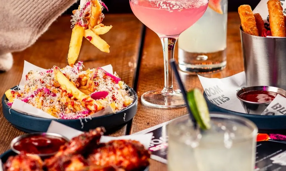 pink cocktail and loaded fries with cheese