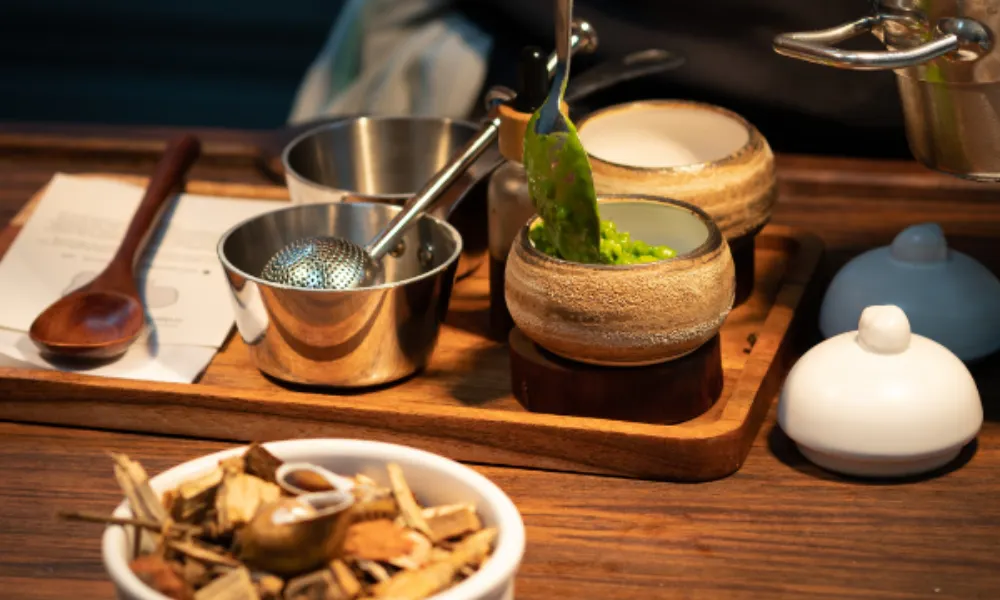 hand spooning peas into a pot