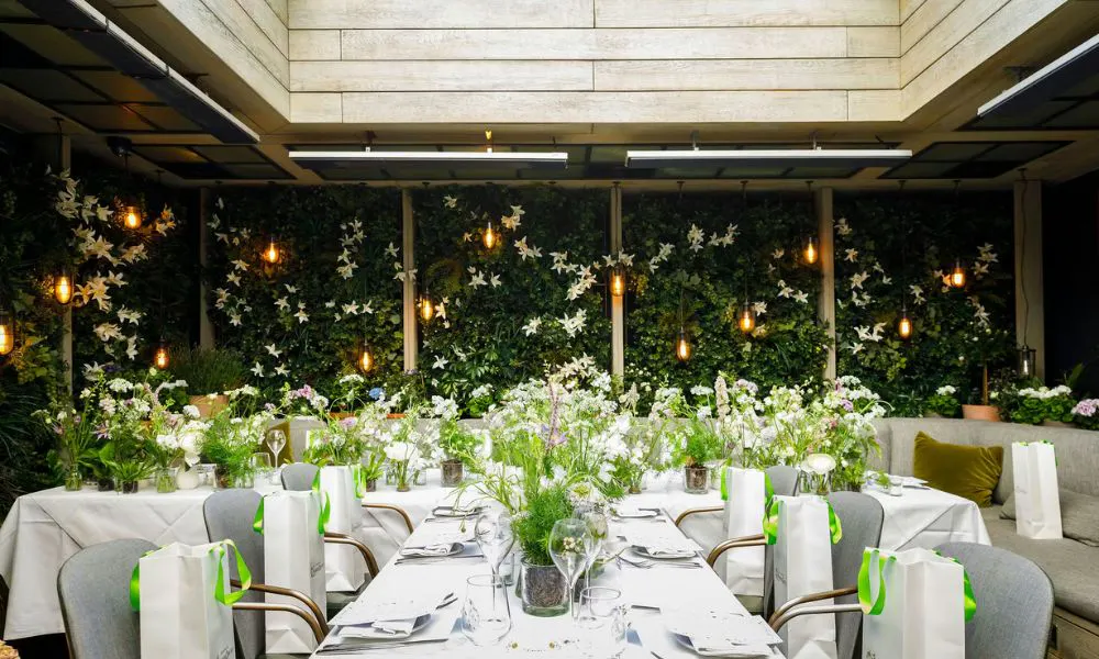 outdoor private dining room at The Hari, decorated with vases of flowers and ivy-draped walls
