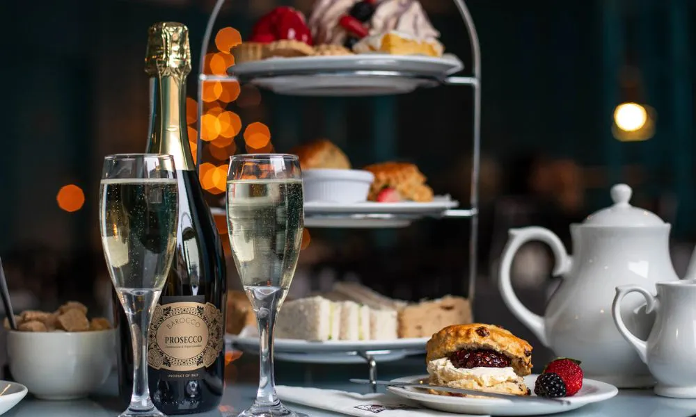 Prosecco, cake, tea pot and scones