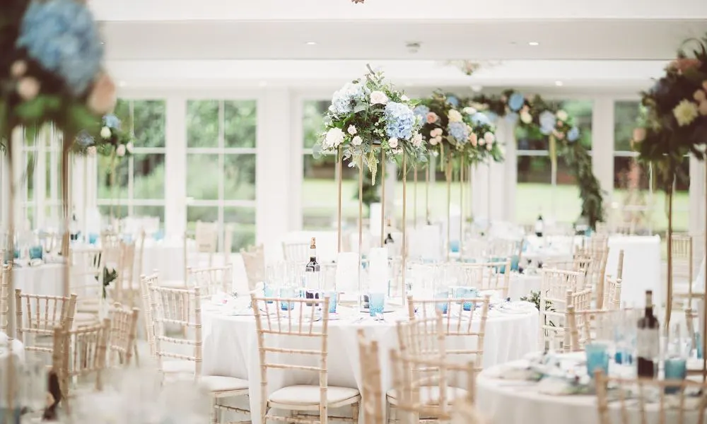 White room with glass doors, flowers, and tables