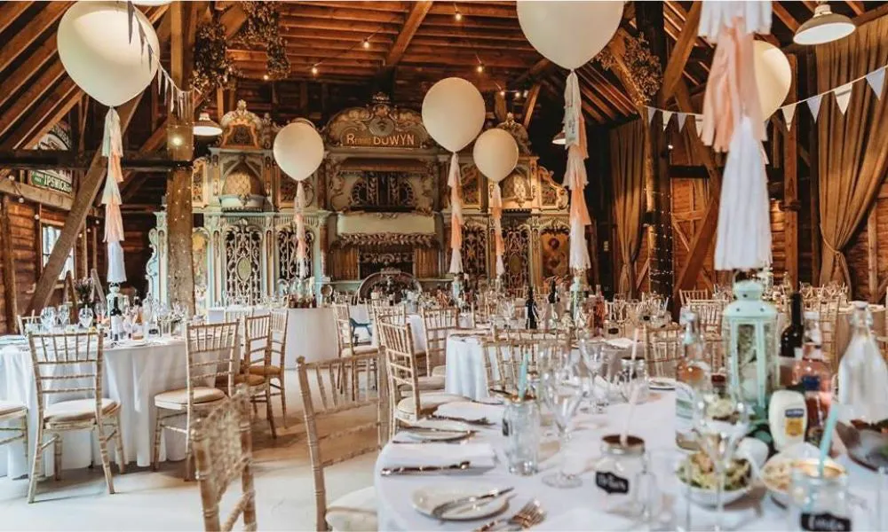Wedding barn with white tables and helium balloons