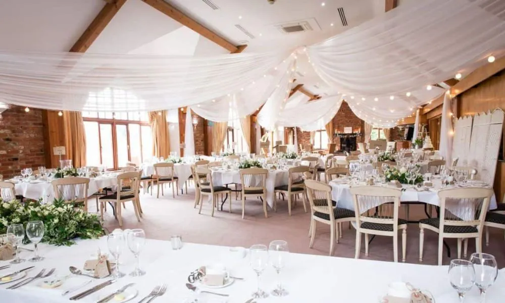Exposed brick room with hanging drapes and tables