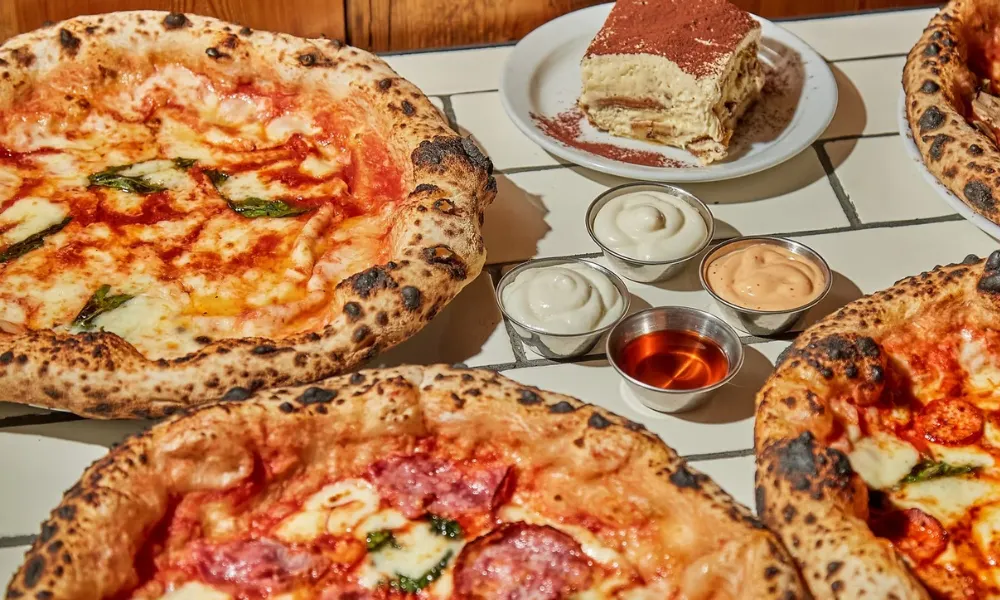 pizza and dips on a tiled table