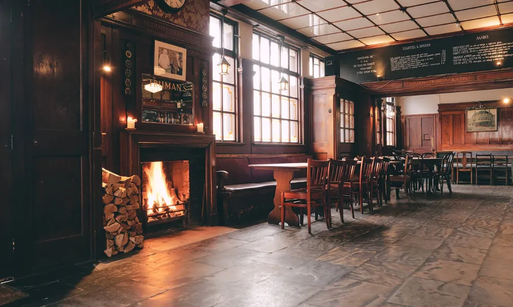 A a pub room glowing thanks to a roaring fire