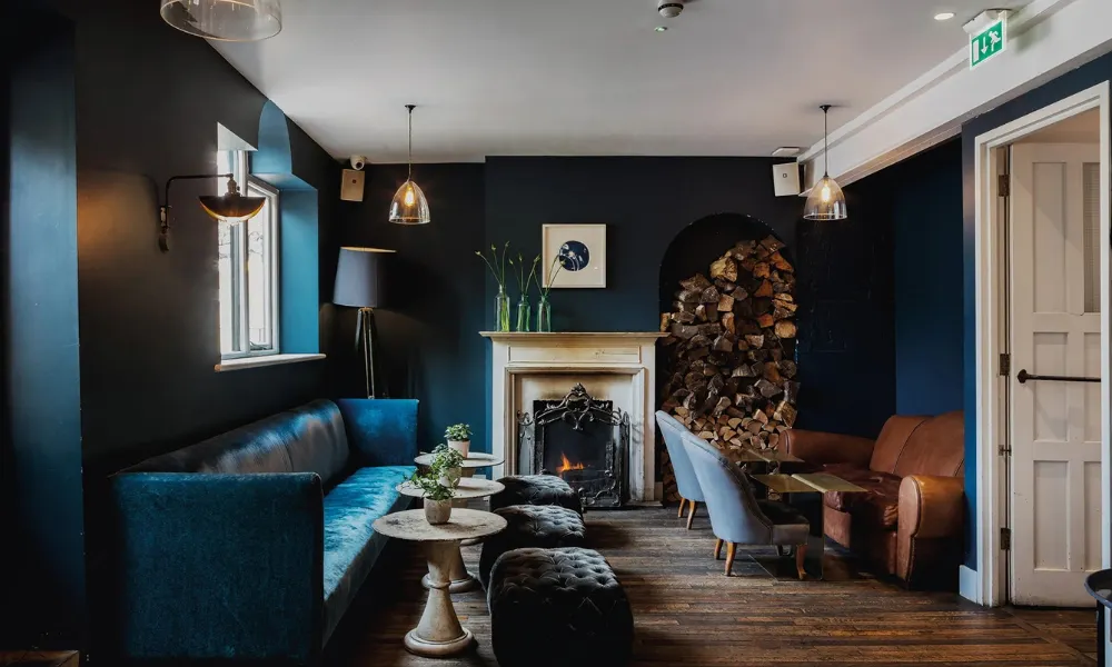 Upstairs pub room with velvet stools and wood fire