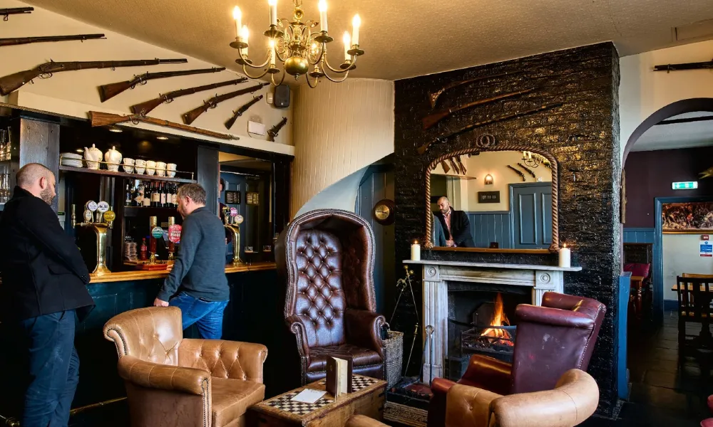 armchairs and a real fire at pub bar