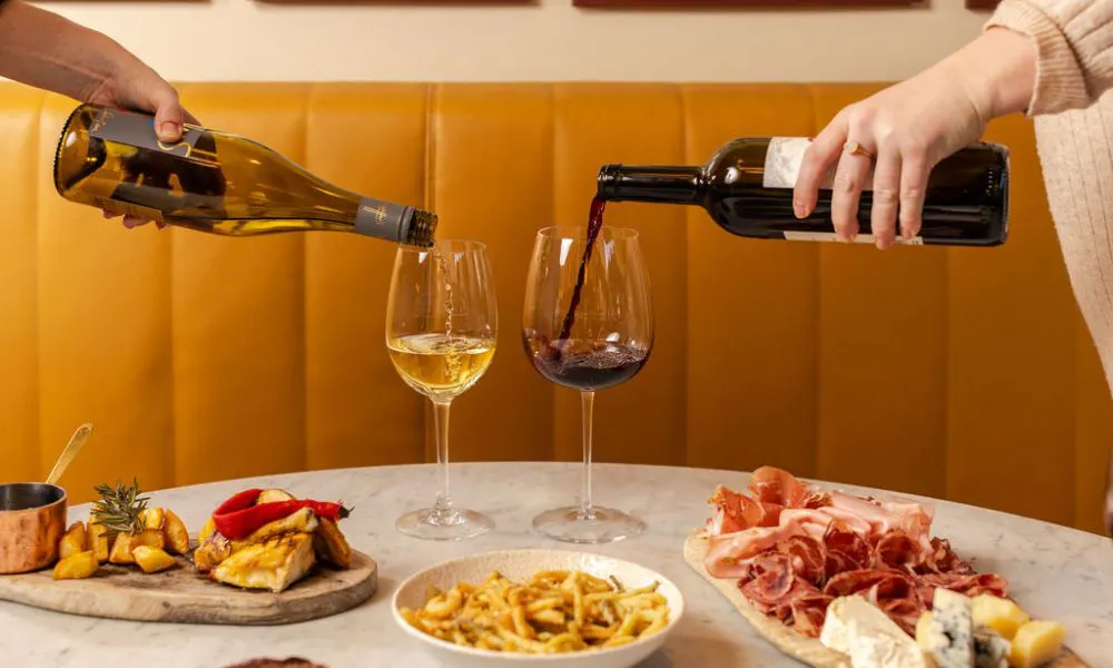 Hand pouring glasses of wine