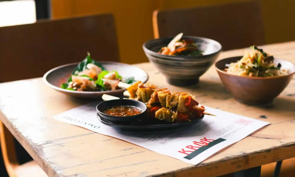 Bowls of Thai food on a wooden table