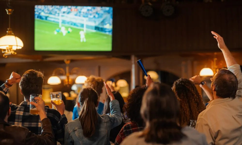 Croads cheering at a screen showing a goal scored