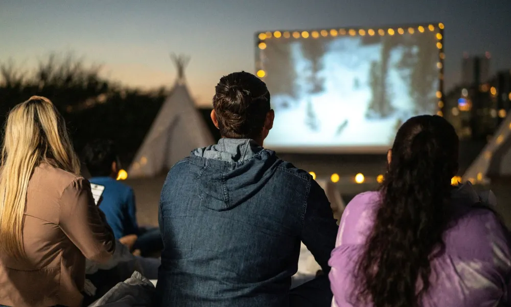 People outside at Raven's Ait watching a big screen