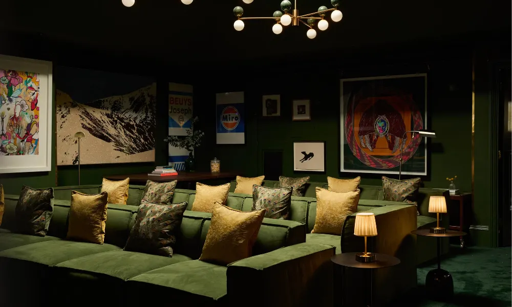 Screening room with green sofas and artwork