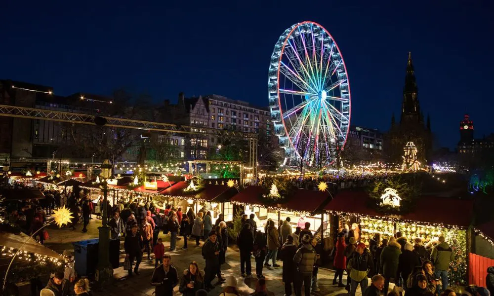 market stalls and huts in front of ferris wheel