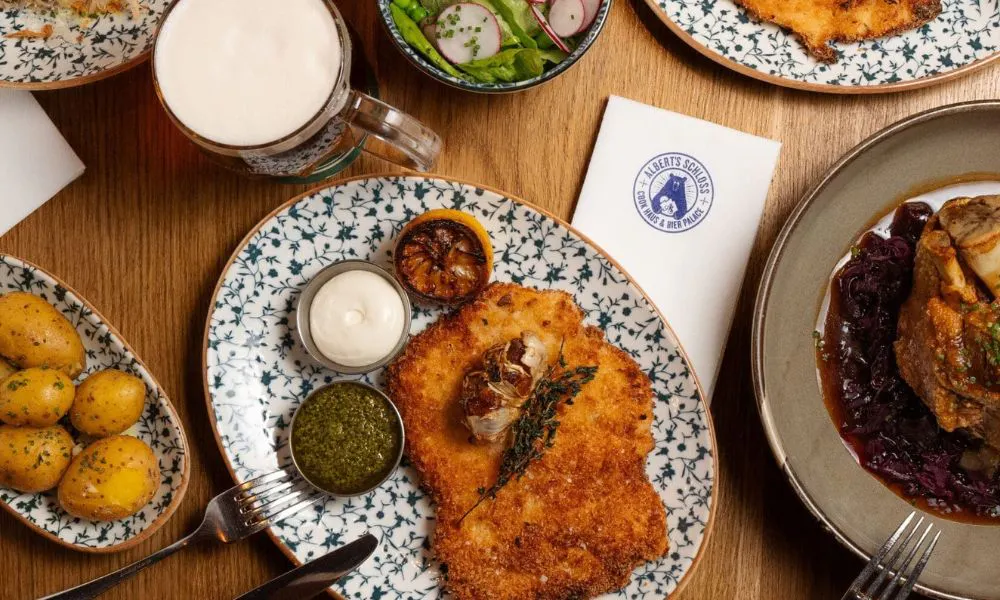 an aerial shot of a chicken schnitzel, and other plates, on a table