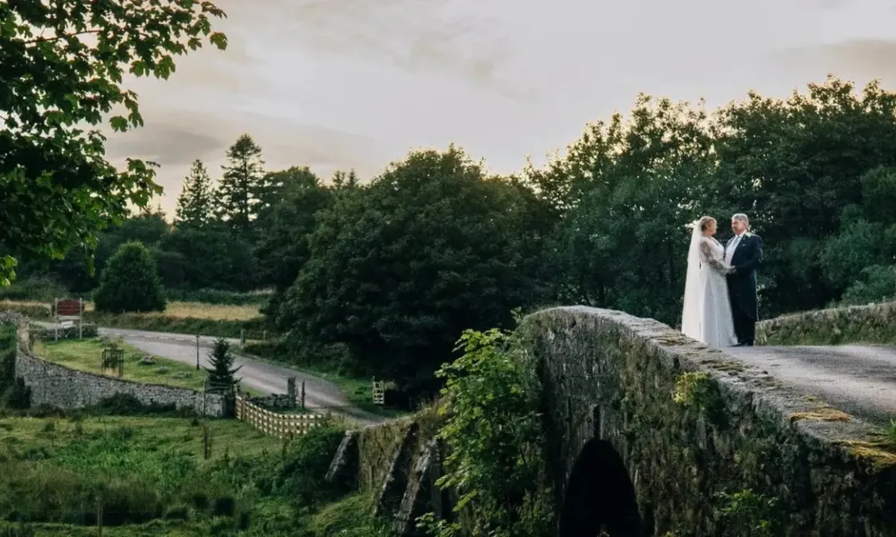 bride and groom pictured on an old bridge