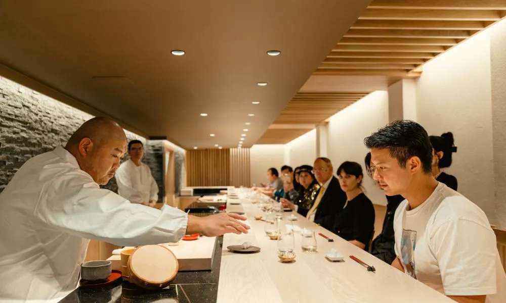 taku handing over sushi at counter