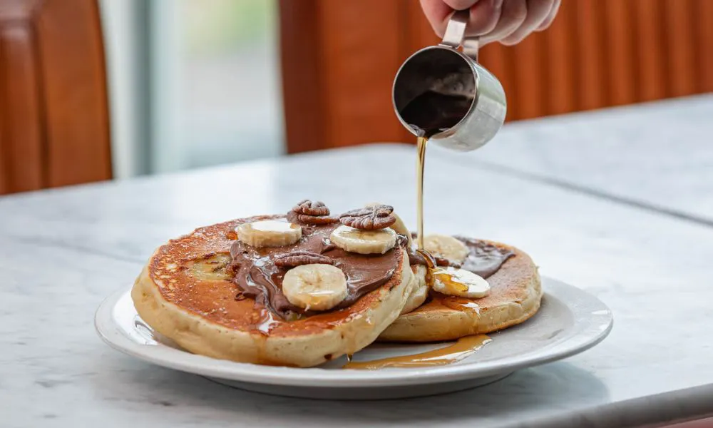 syrup poured on banana chocolate pancakes