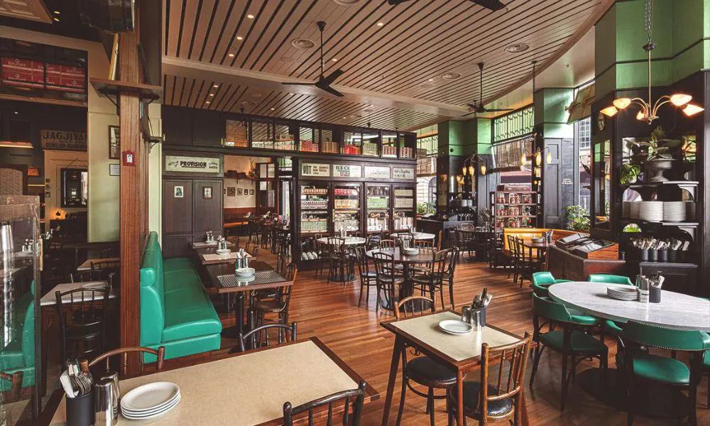 Interiors of dishoom with green sofas and wood chairs