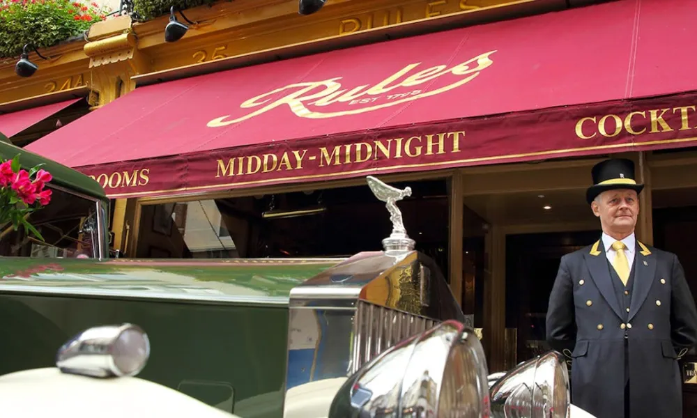 red awning and doorman at rules