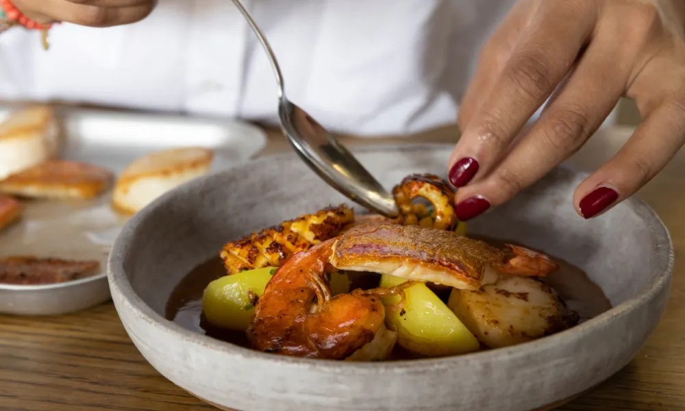 Sabrina plating her masala bouillabaisse