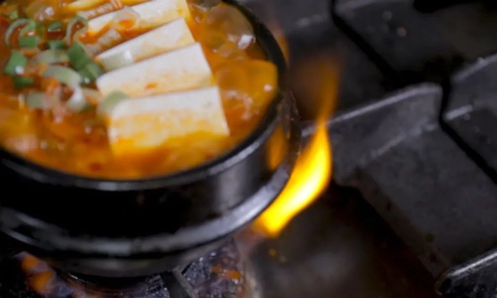 Kimchi tofu cooking over flames