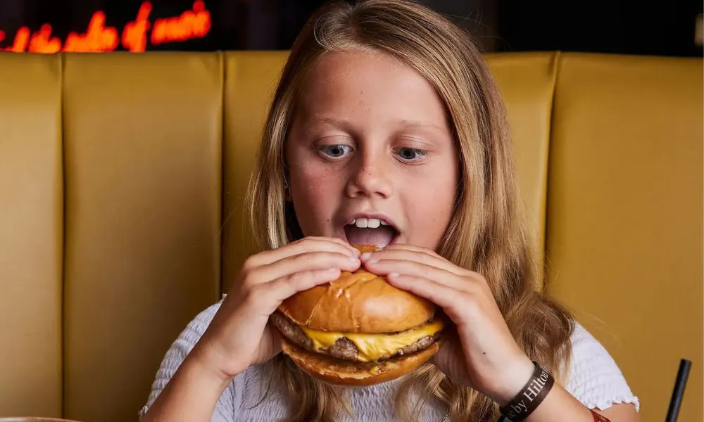  a child eating a burger
