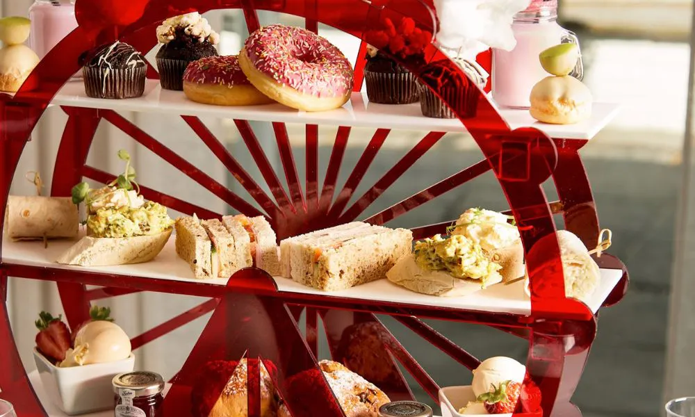 a ferris wheel stand of of cakes and sandwiches