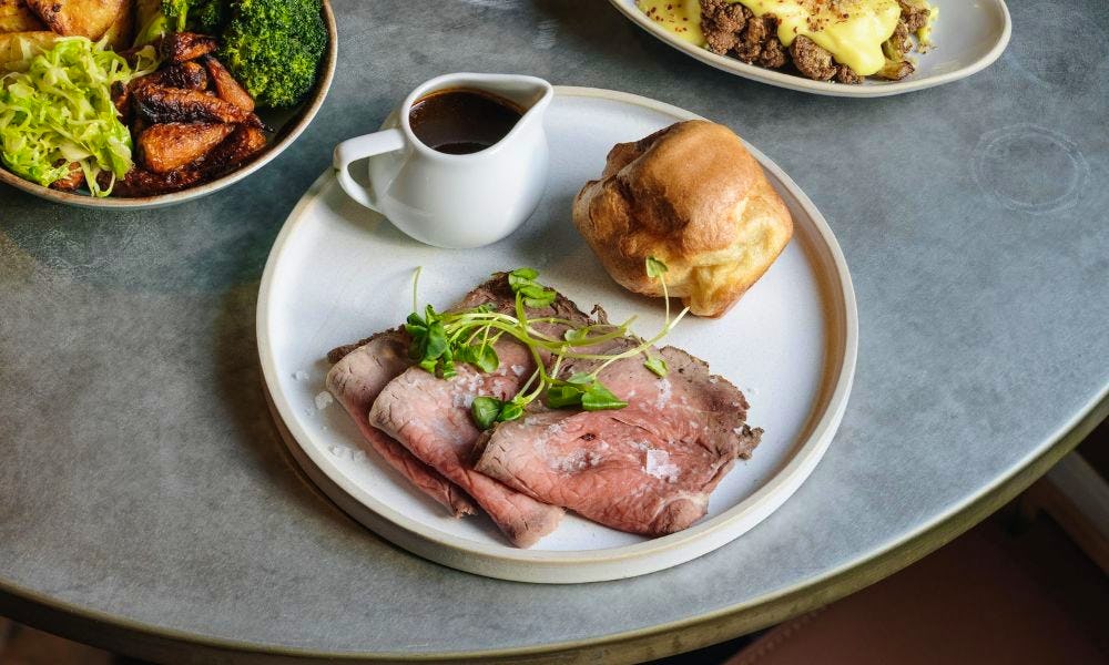 roast beef with a jug of gravy and a yorkshire pudding 