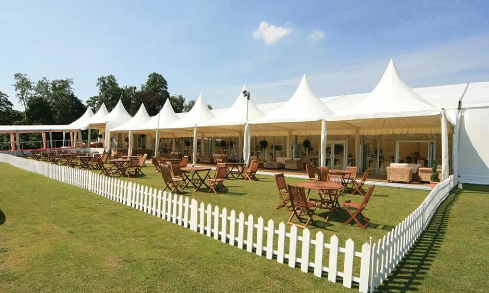 Large white tent with benches at the front