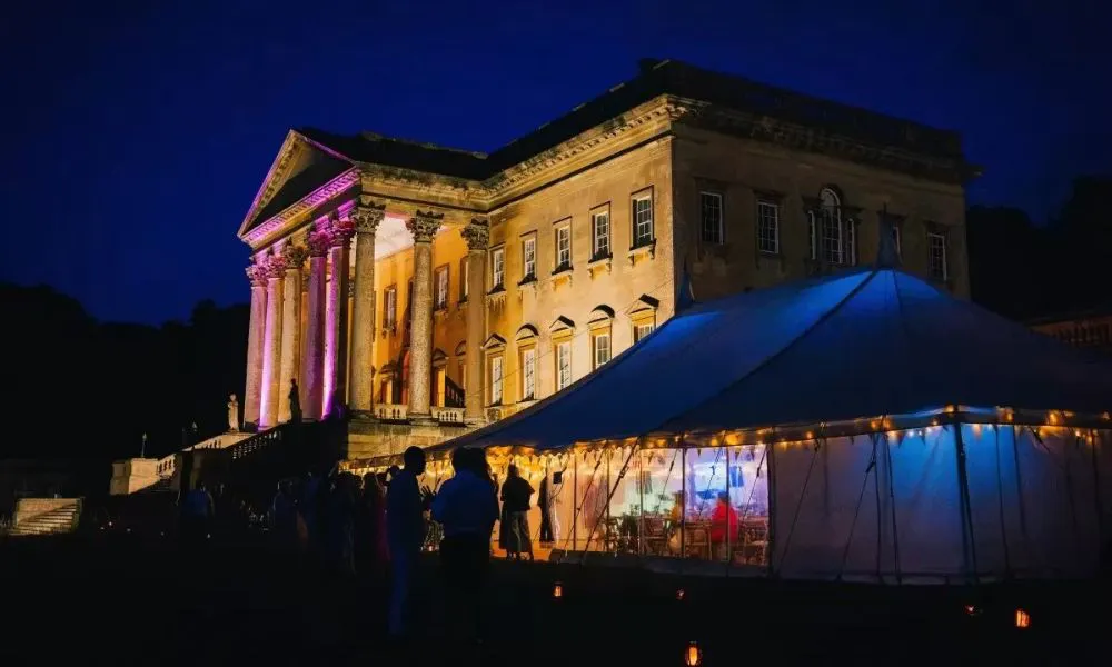 grand house with marquee at night time