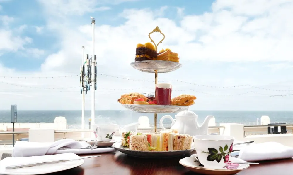 a stand of cakes and sanwiches for afternoon tea by the sea
