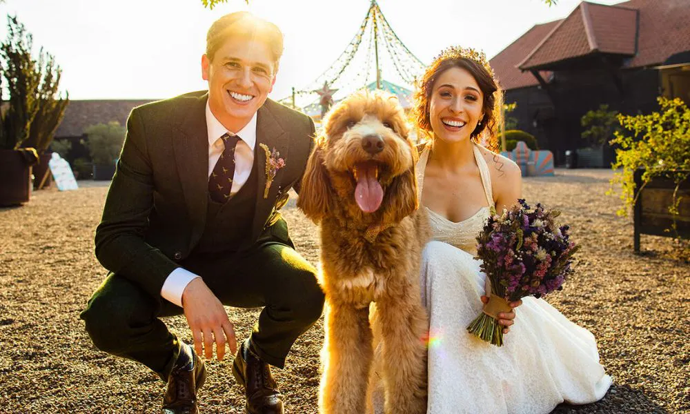 A bridge and groom posing for photos with their dog