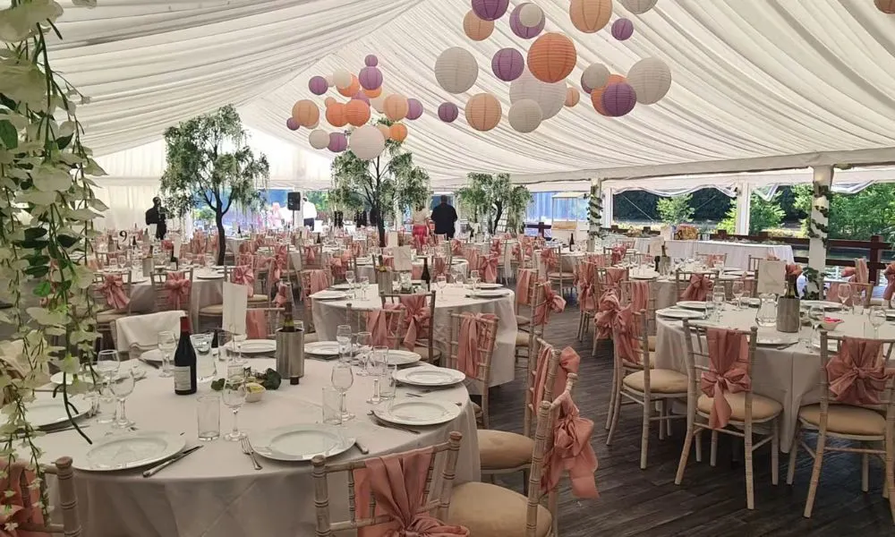 marquee decorated with round tables and balloons