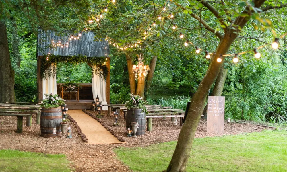 Forest wedding ceremony space with festoon lighting