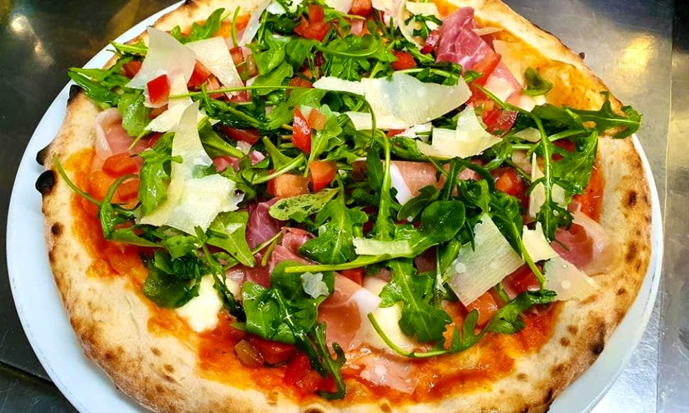 a rocket and prosciutto pizza