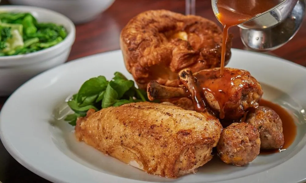 chicken roast dinner with gravy being poured over
