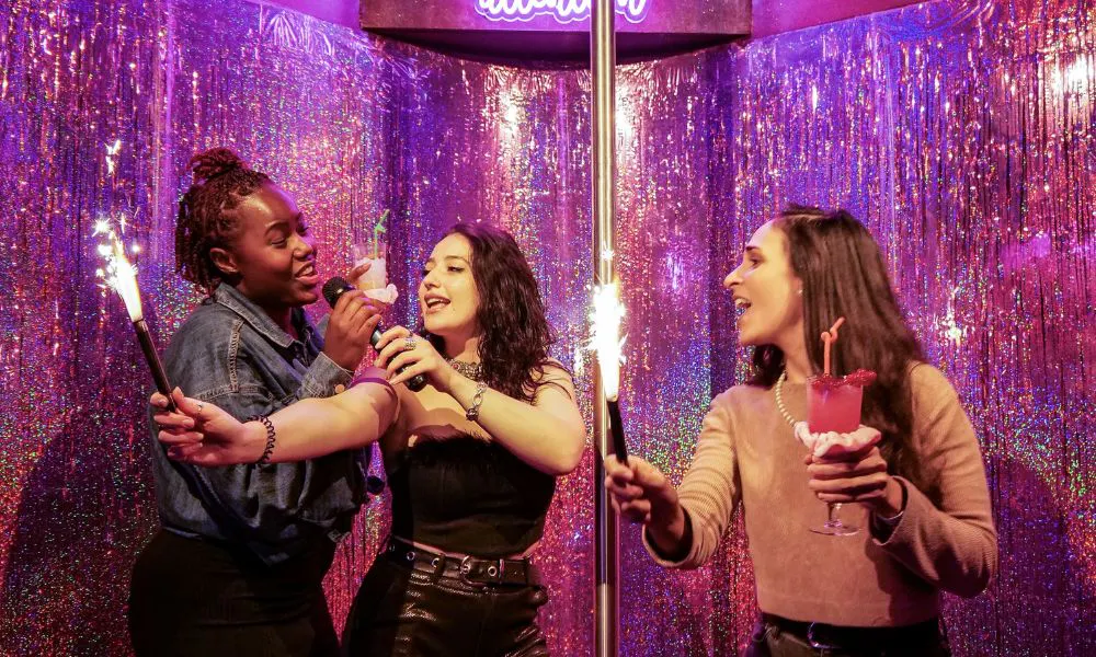 Three women doing karaoke