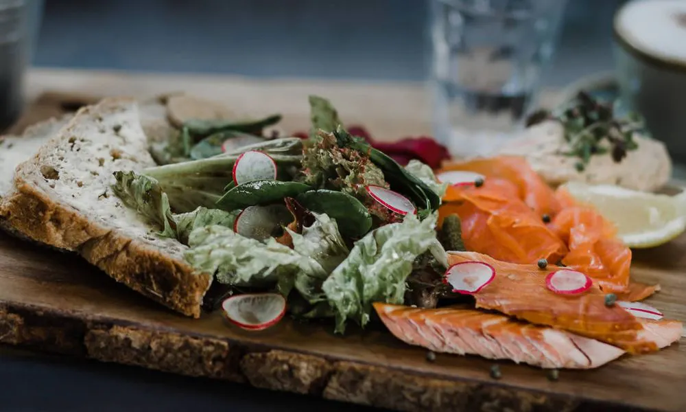 salmon and bread on wooden board