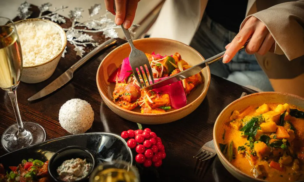 someone eating a selection of Indian dishes