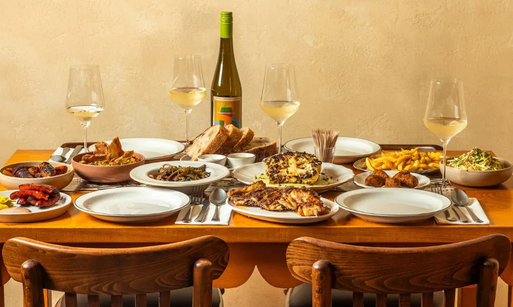 a table spread with glasses of wine and Portuguese dishes