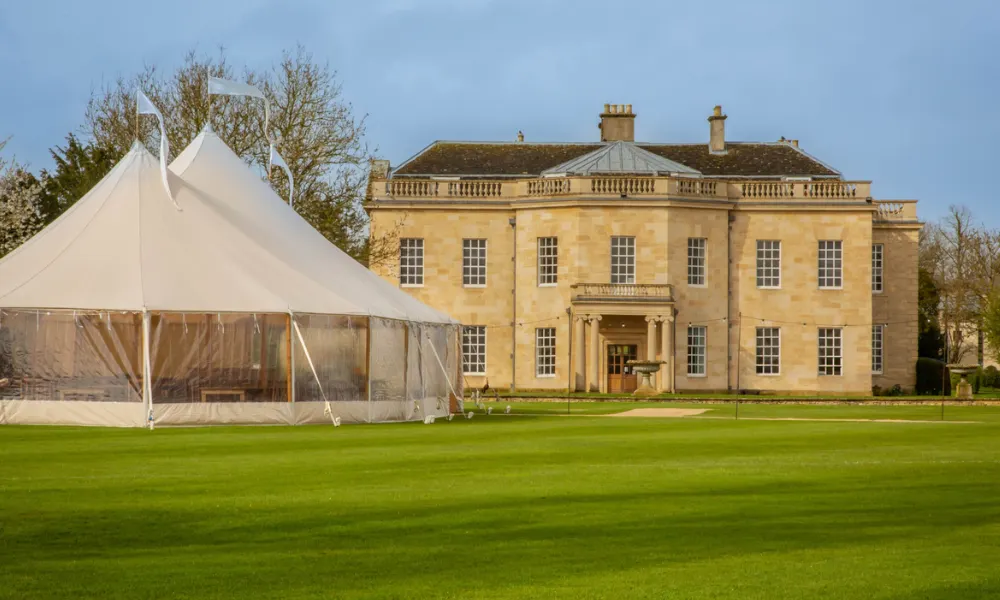 country house exterior in yellow stone with marquee