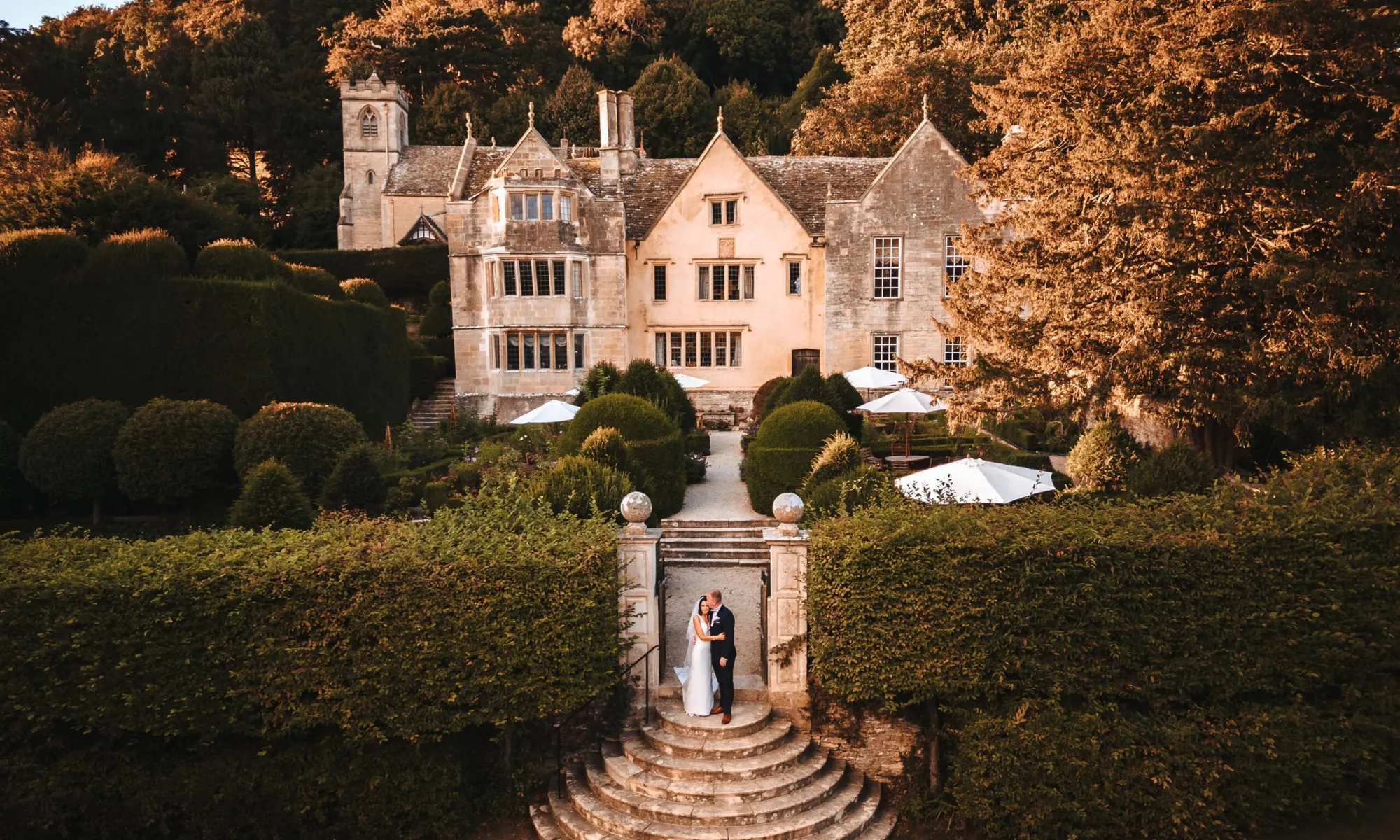 Exterior of manor house with couple on the steps 