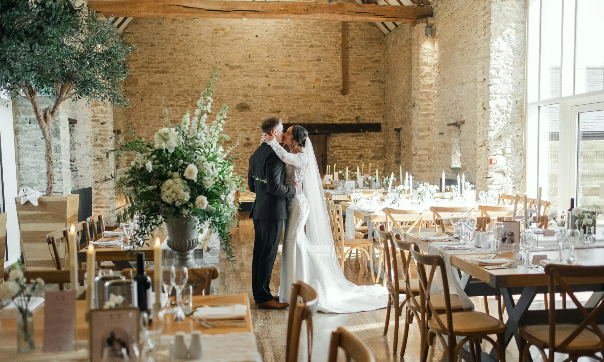 Bride and groom in barn set up for wedding breakfast