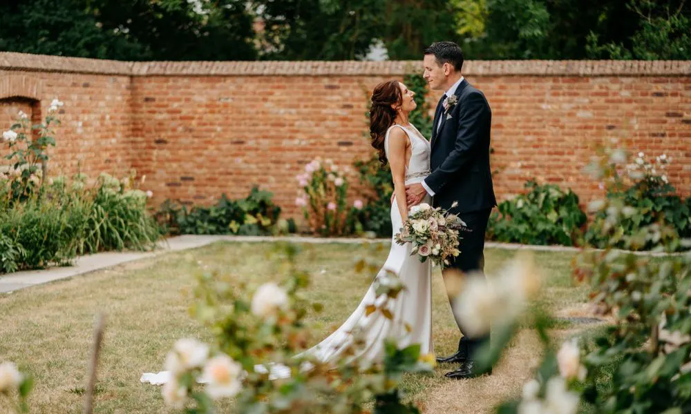 bride and groom standing in a courtyard garden