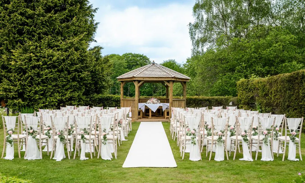 a wedding ceremony set up infront of a wooden marquee