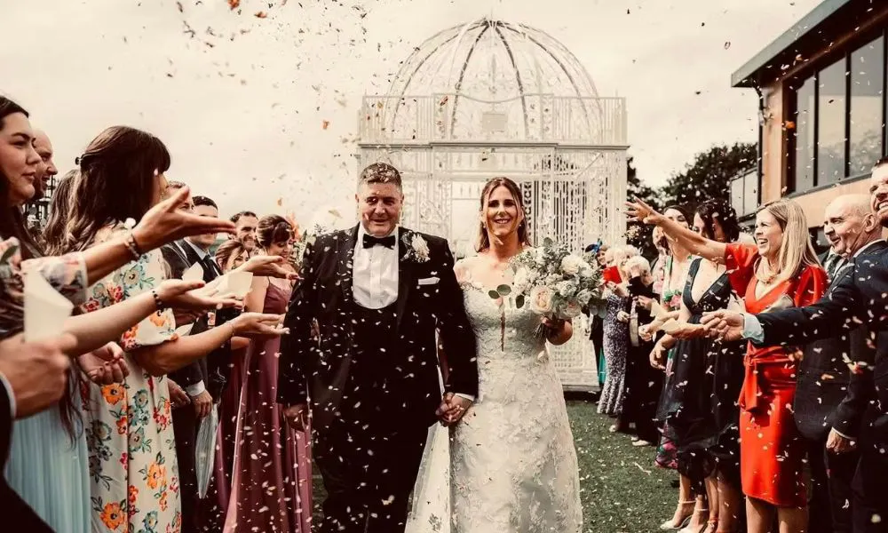 a bride and groom just married, with crowds throwing confetti