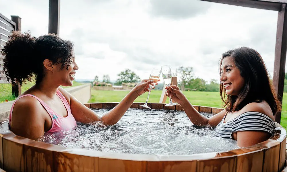 two people drinking prosecco in a hot tub