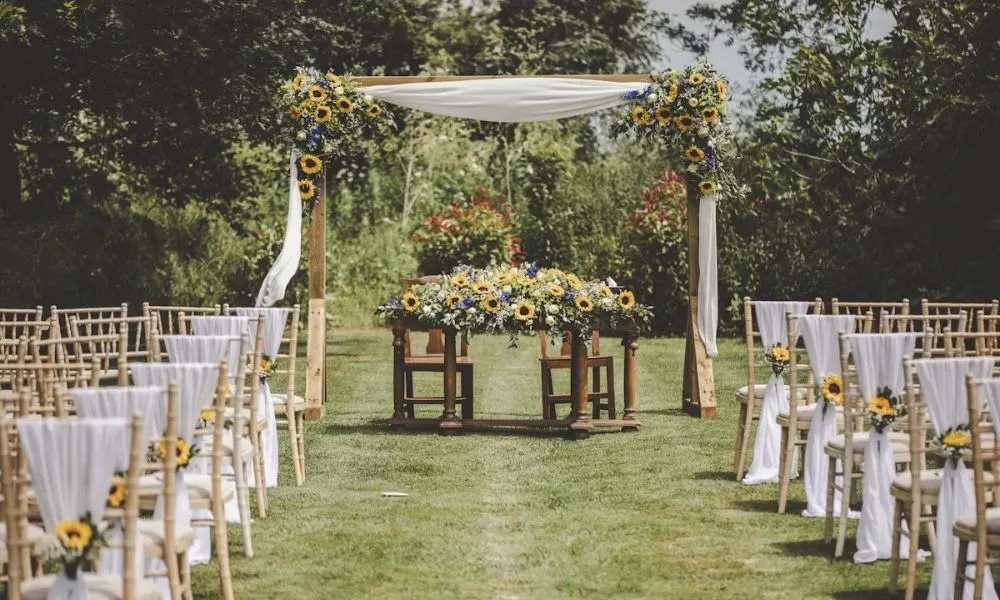 An outdoor summer wedding aisle decorated with sunflowers
