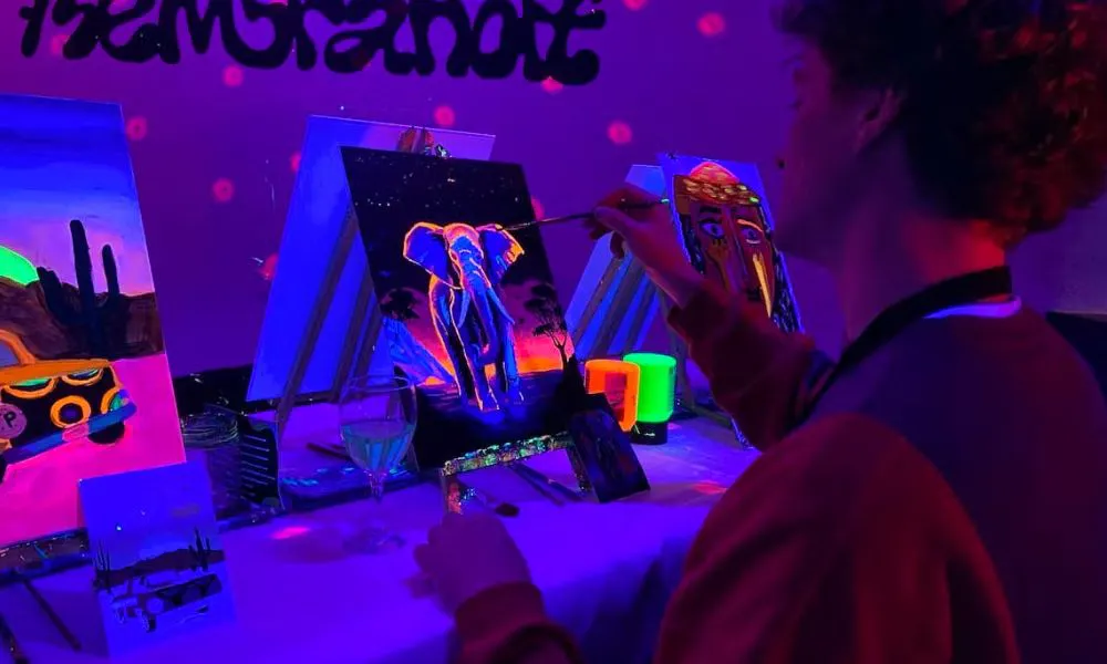 someone painting with glow in the dark paint at a paint and sip evening